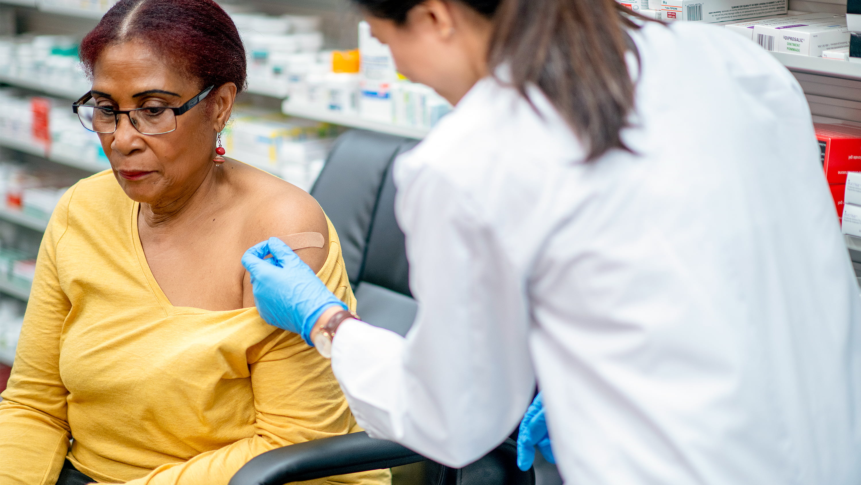 Older woman gets a vaccination at a pharmacy. (Photo: Getty Images)