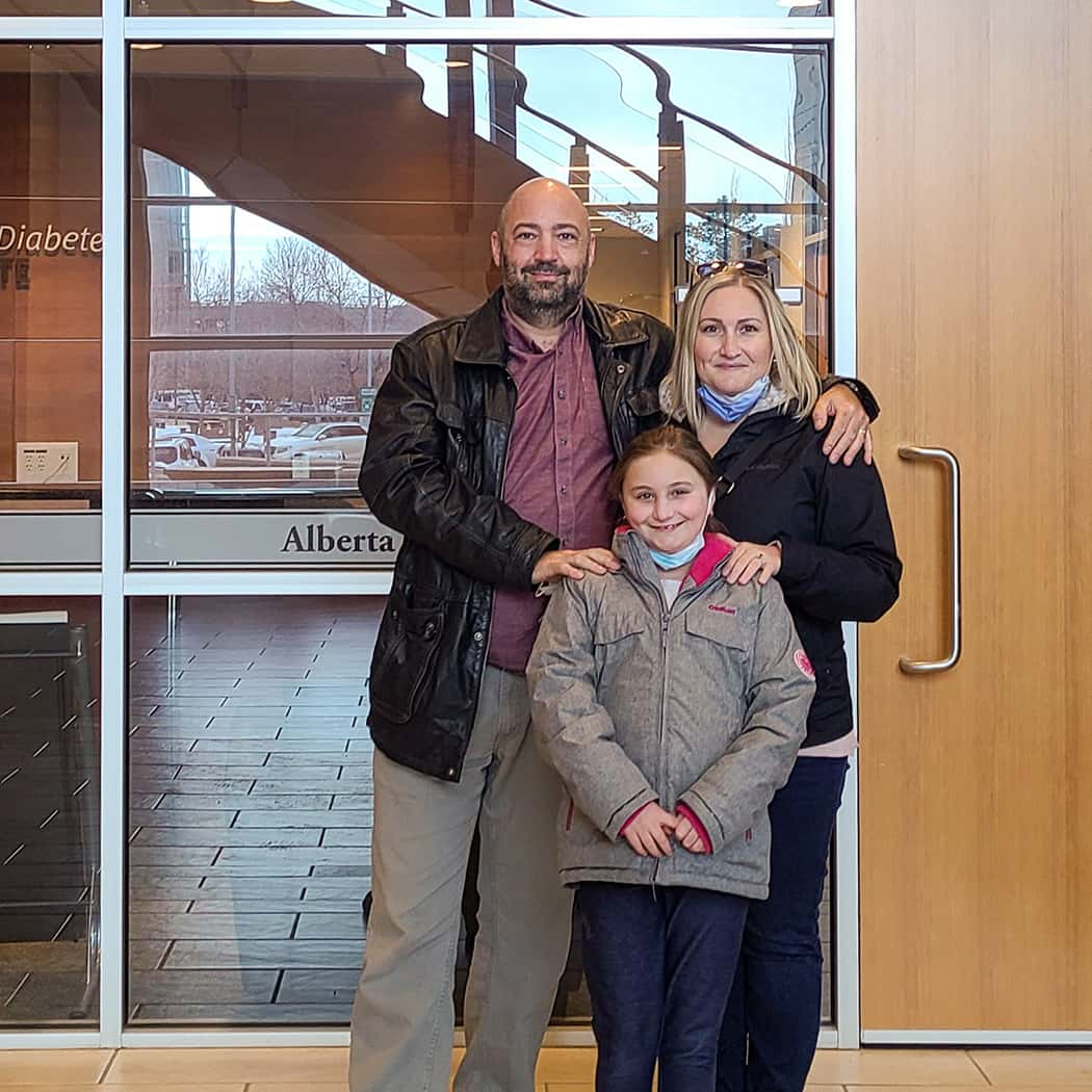 The Quinlan family standing in front of the Alberta Diabetes Institute