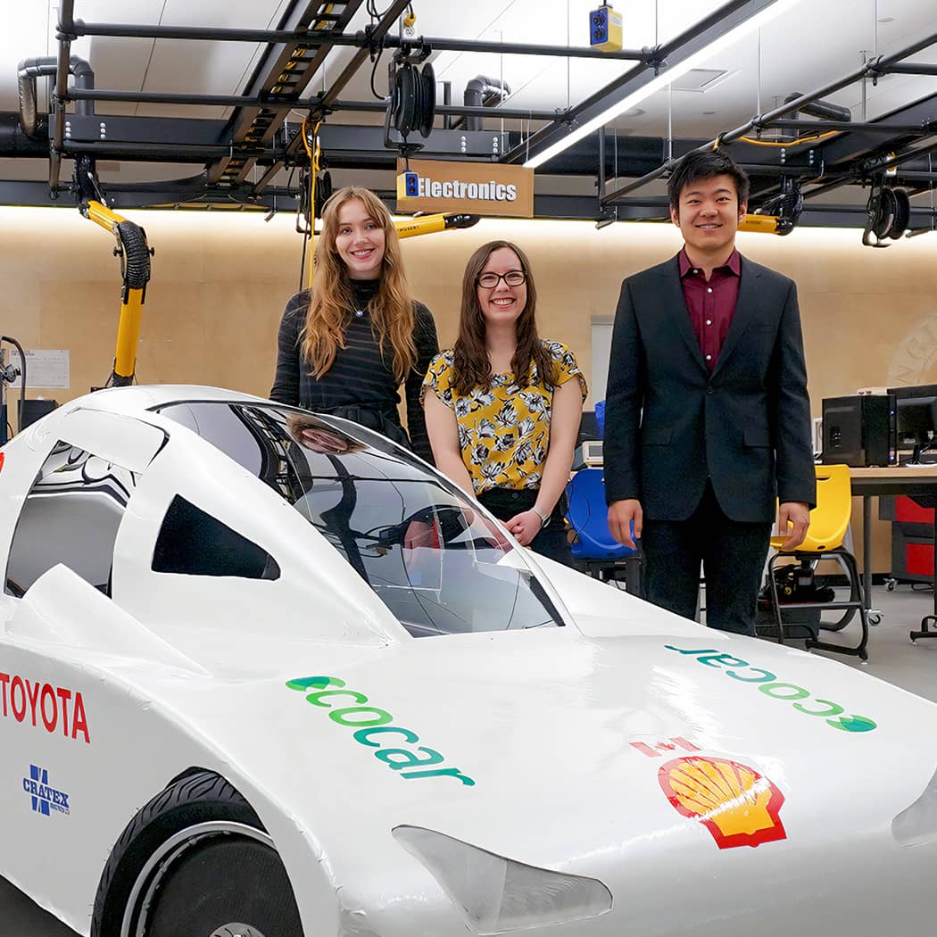 Engineering students standing by their EcoCar project