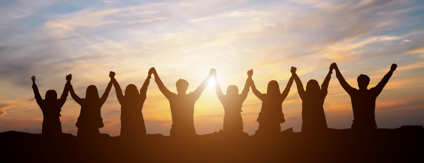 eight people standing in a line holding hands up