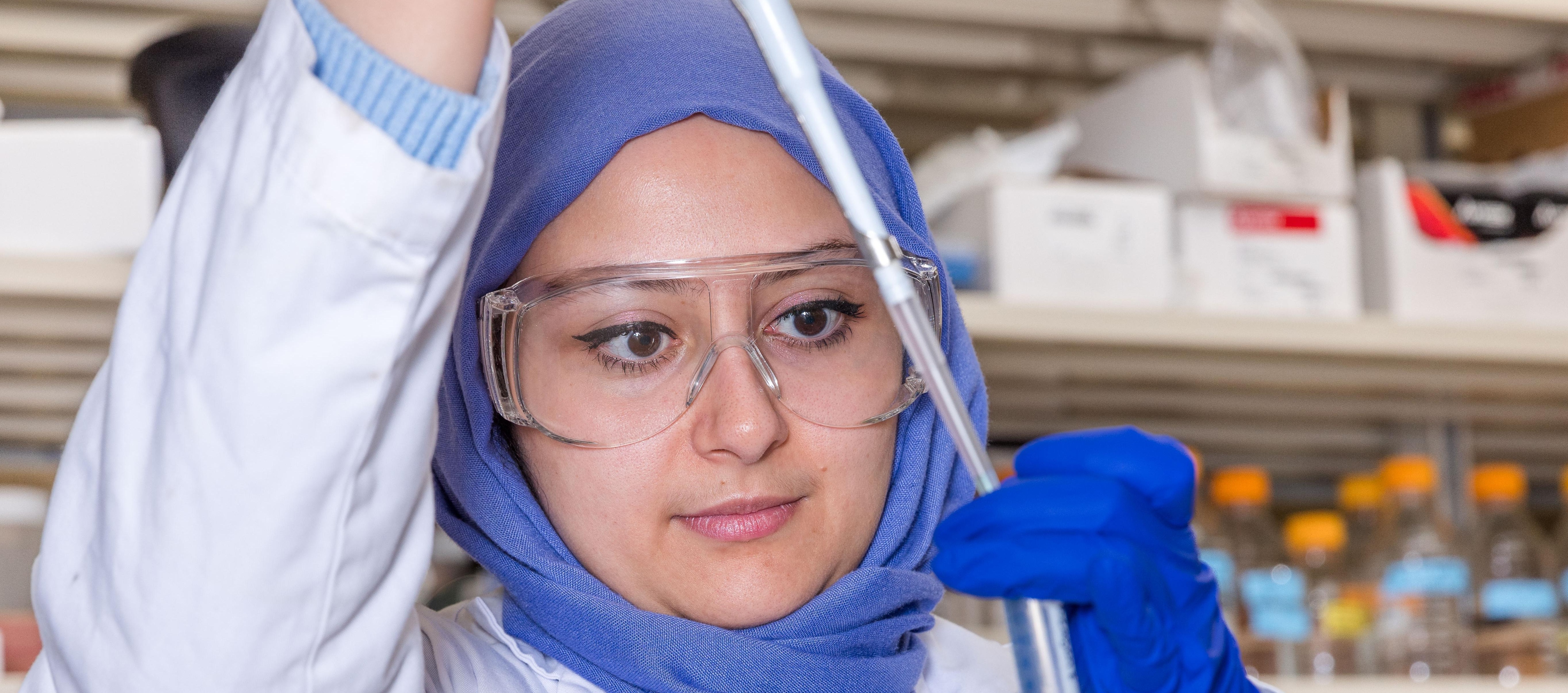 Woman putting something into a test tube