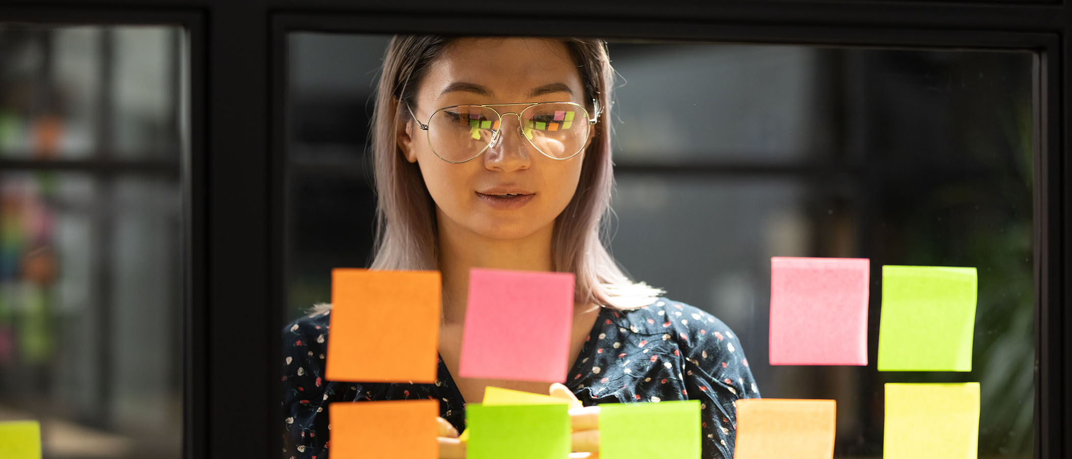 Person process mapping with sticky notes on a window