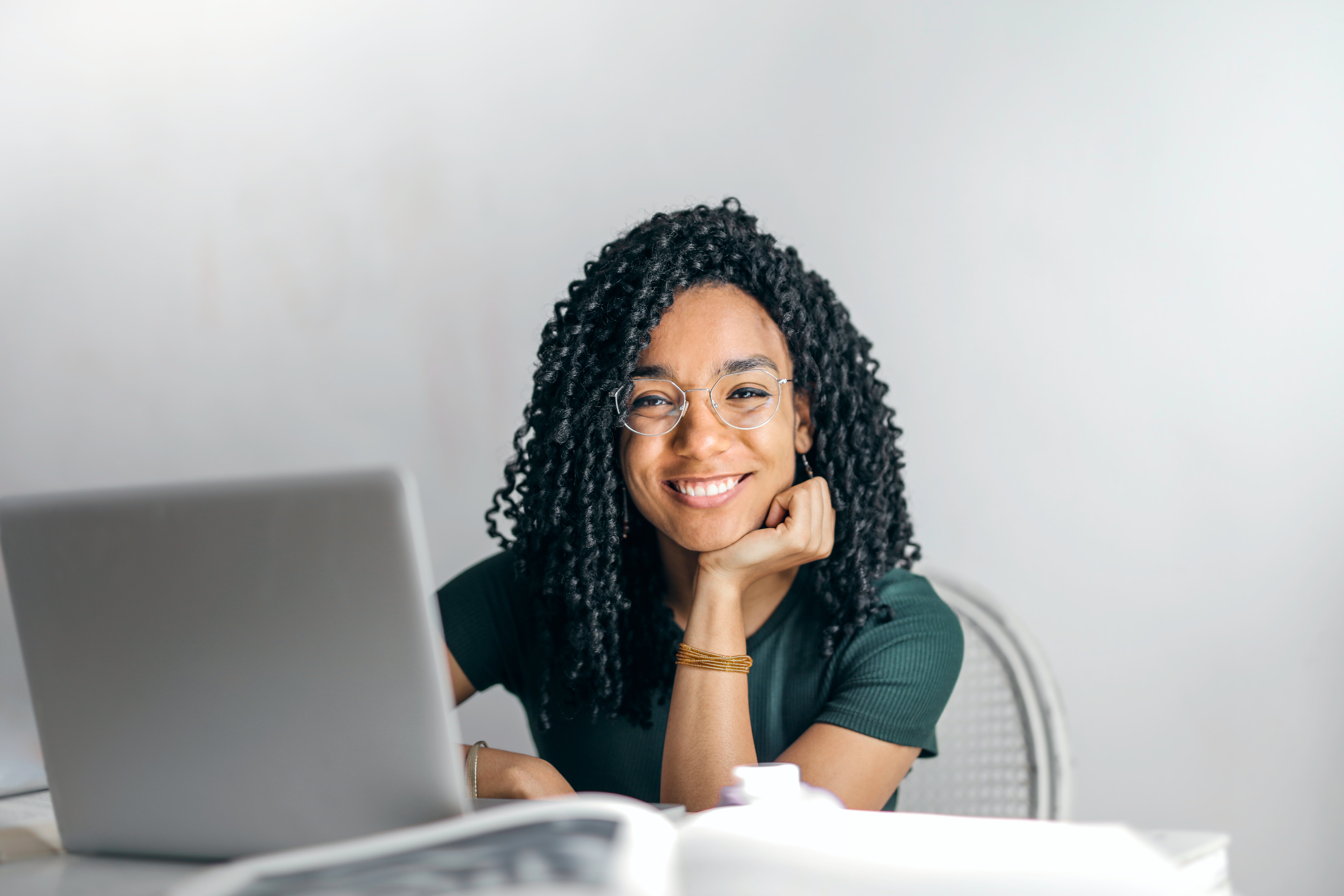 Person at table with laptop smiling