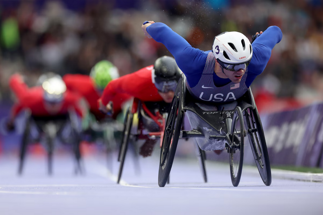 paralympic athletes competing in a race on wheels.