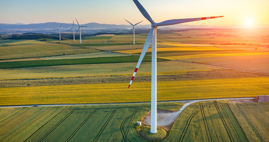 Wind turbines in a field against a sunrise