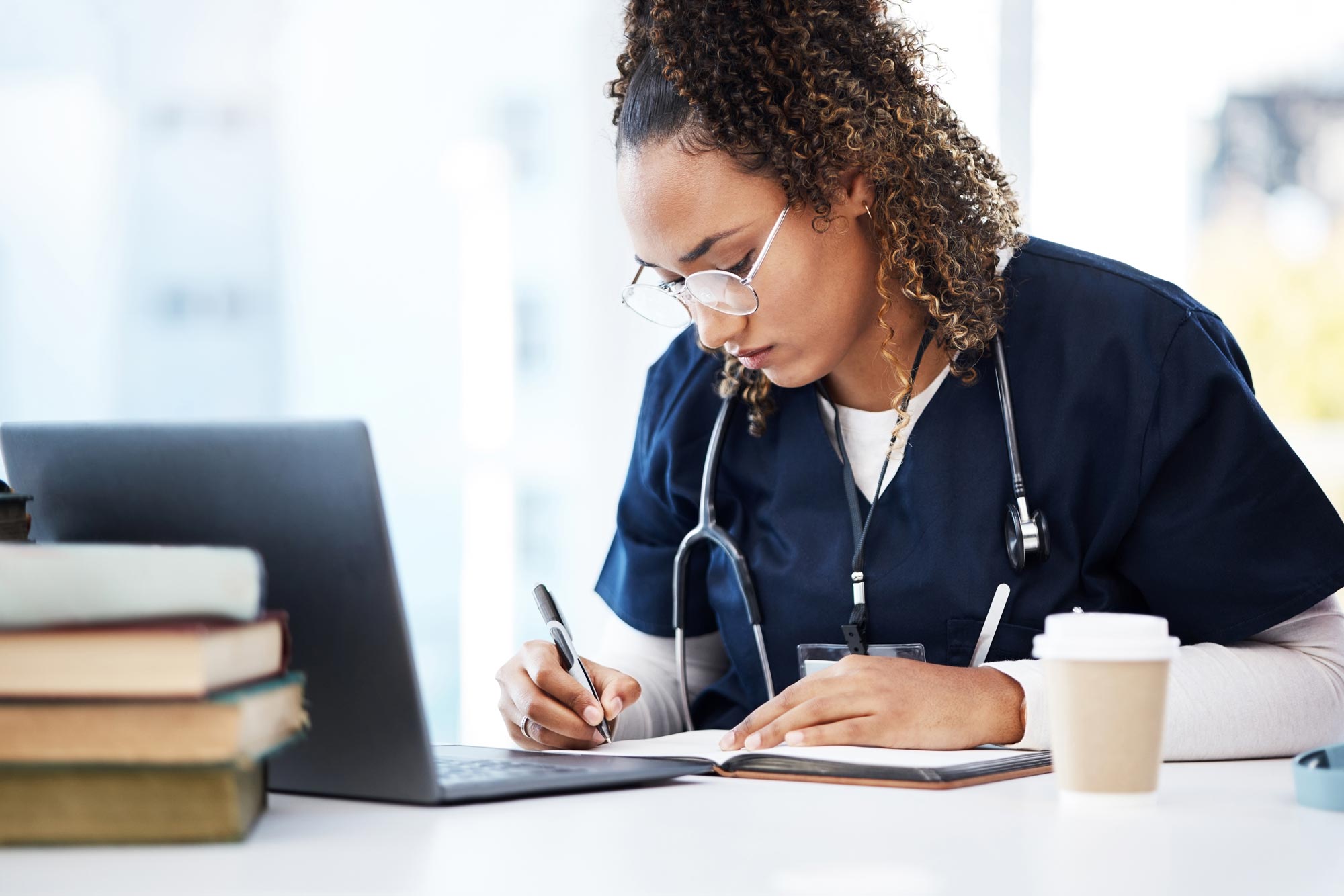 Person in medical scrubs writing in a day journal