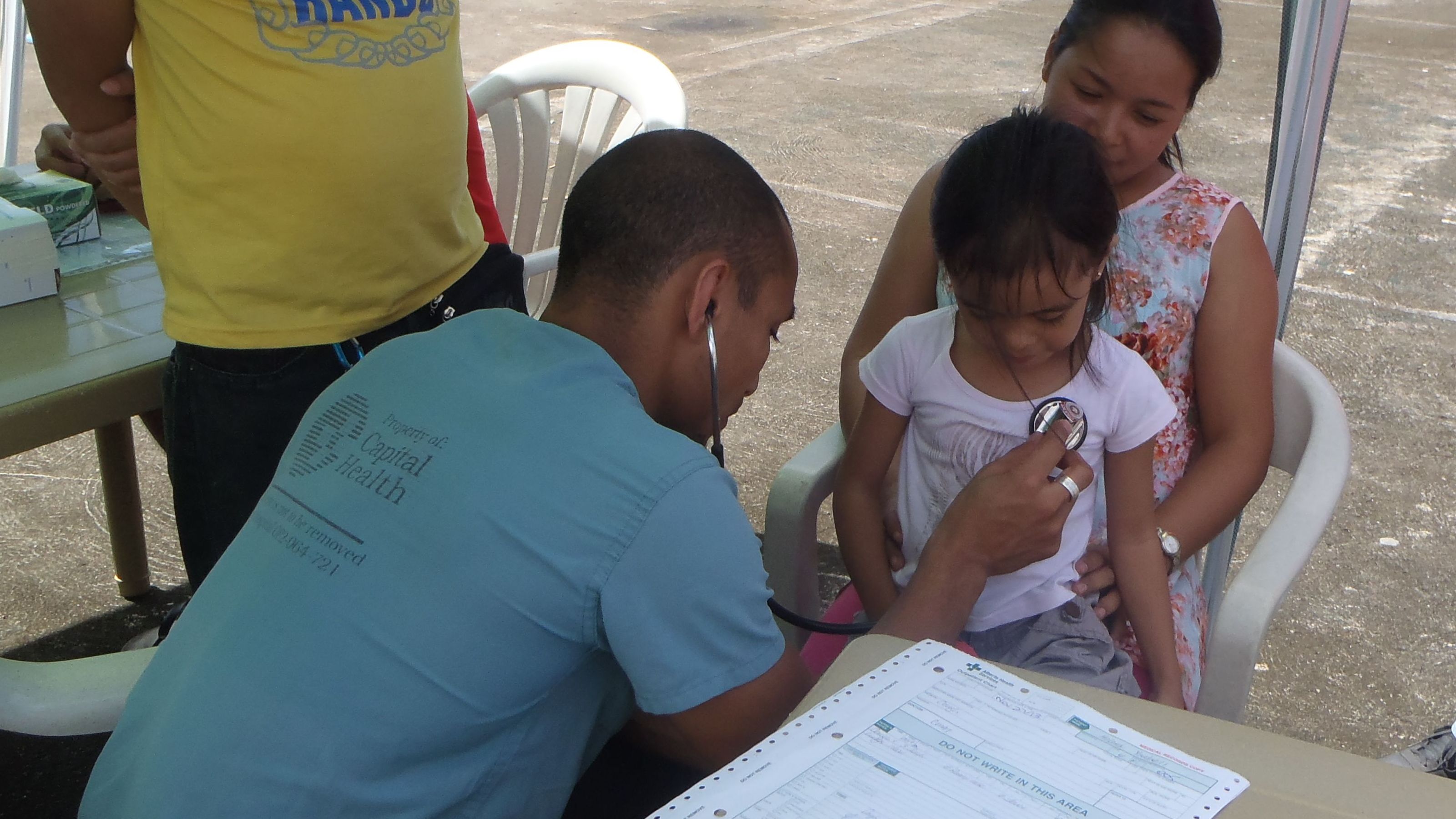 Rashad Chin treats a young patient while on deployment in the Philippines