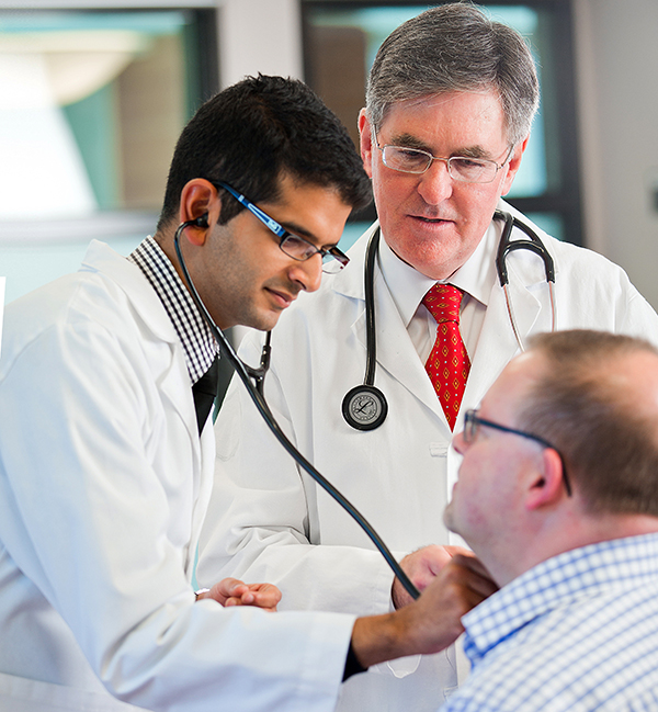 Irfan Kherani, former MSA president, and Dr. Douglas Miller, dean of the faculty, see a patient.