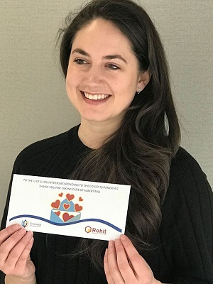 Zosia Prus-Czarnecka holding a gift envelope from ROHIT group and Covenant Foundation