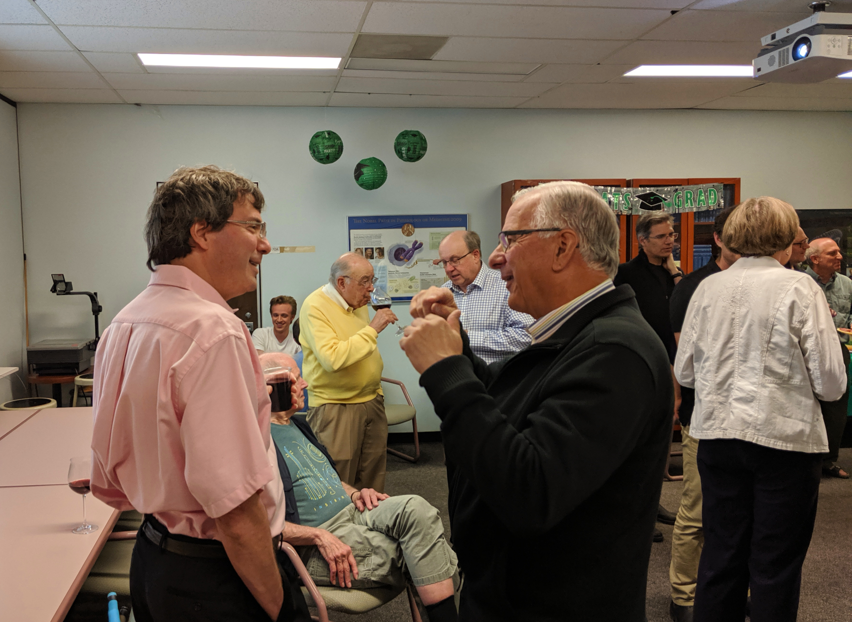 Lewis Kay in earnest discussion with Brian Sykes in a room of people networking