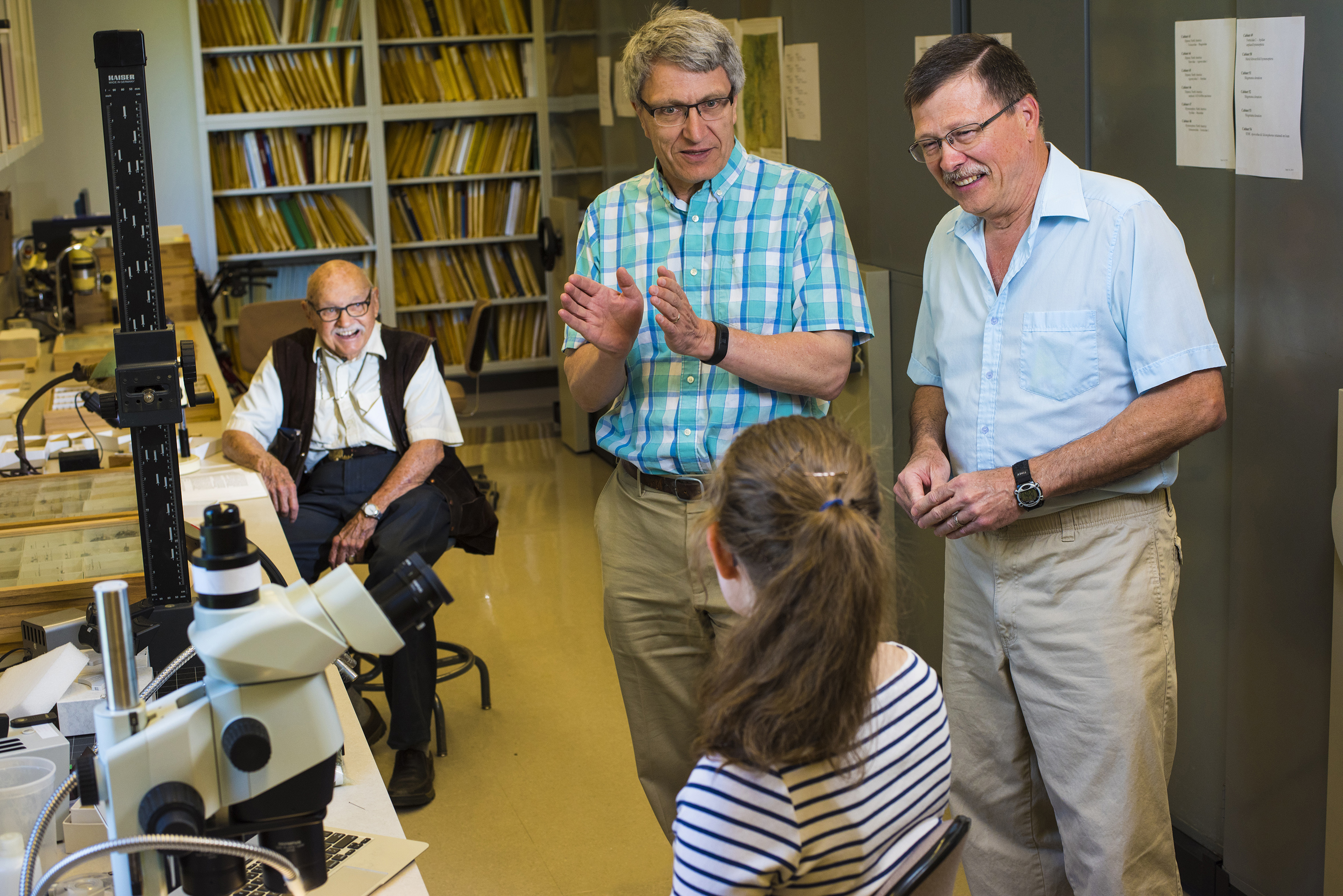 A group of individuals stand around discussing.