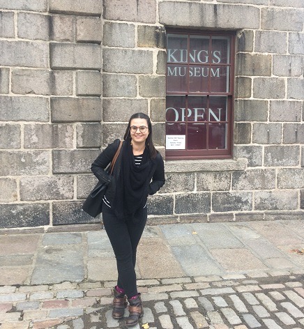 Jean standing outside of a stone building on a stone street