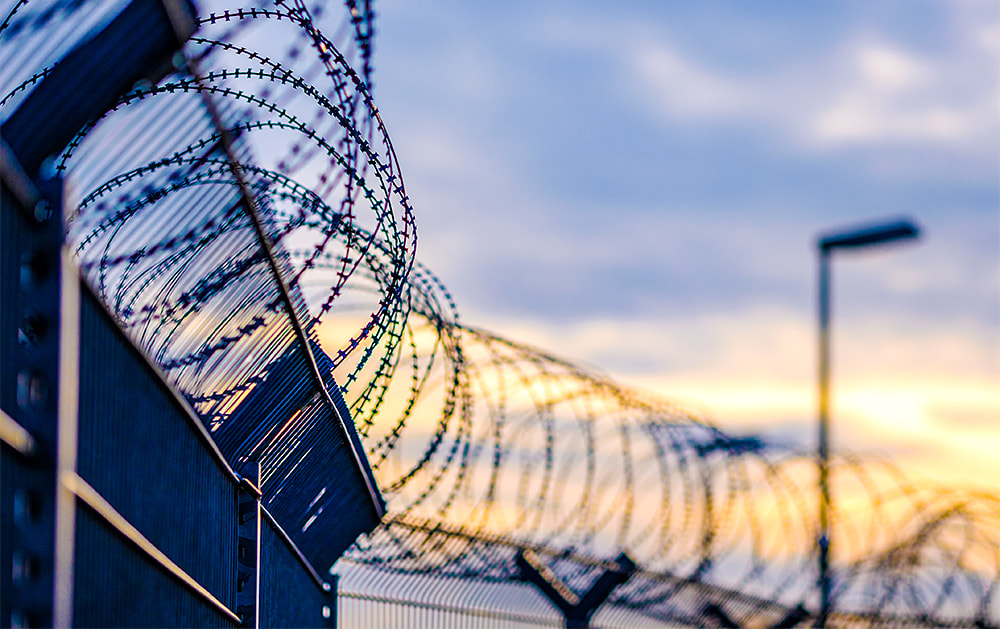 Razor wire fence against the sky at dusk