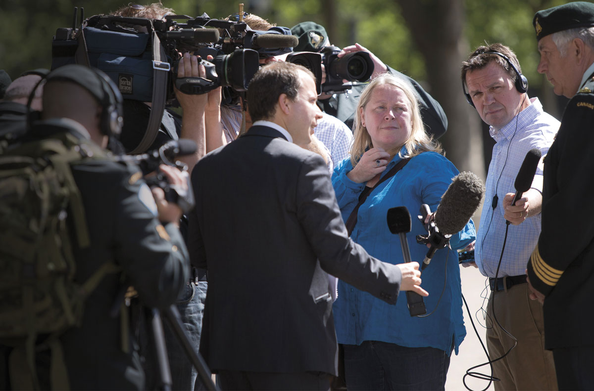 Margaret Evans in the middle of a press scrum