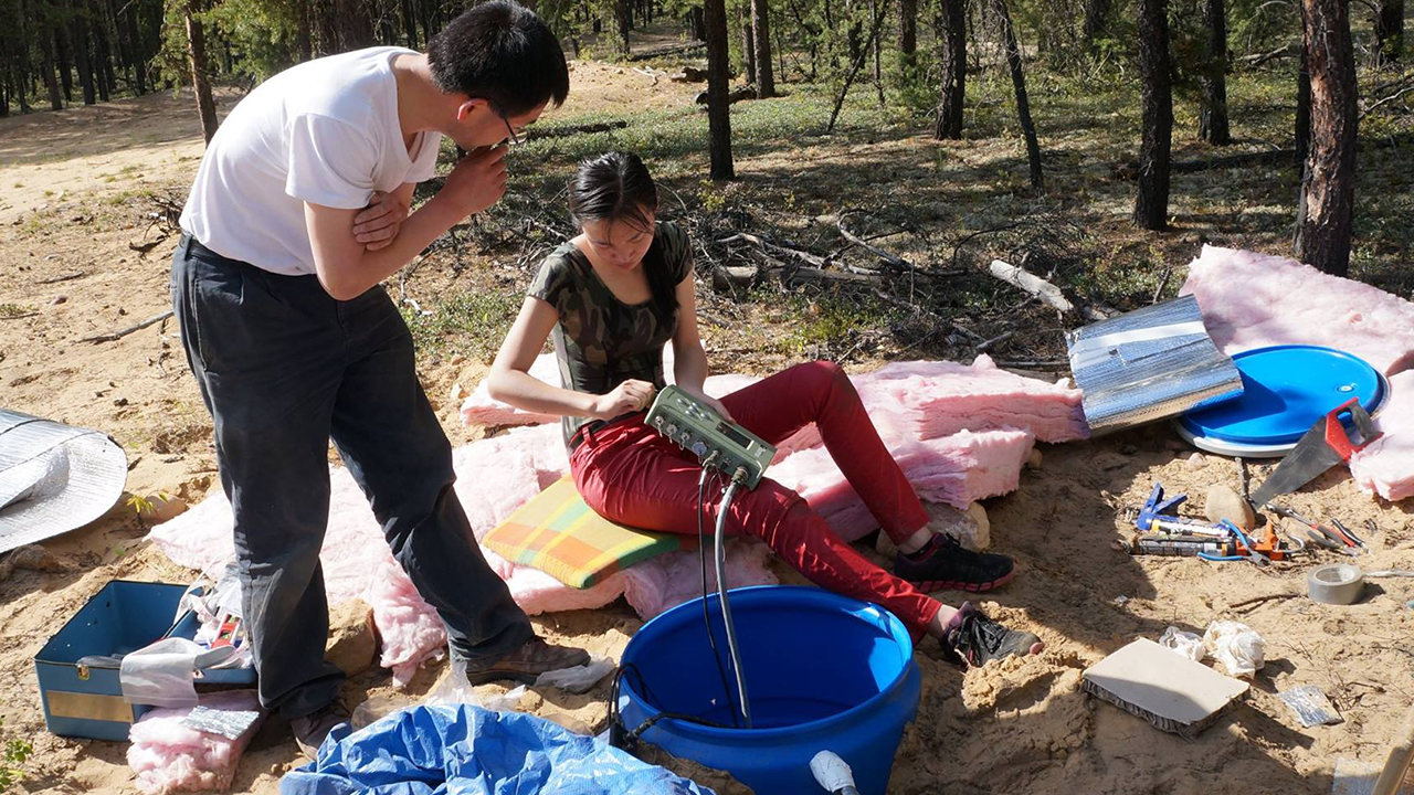 Associate professor Jeff Gu and graduate student Ruijia Wang work on a seismic station in the field.