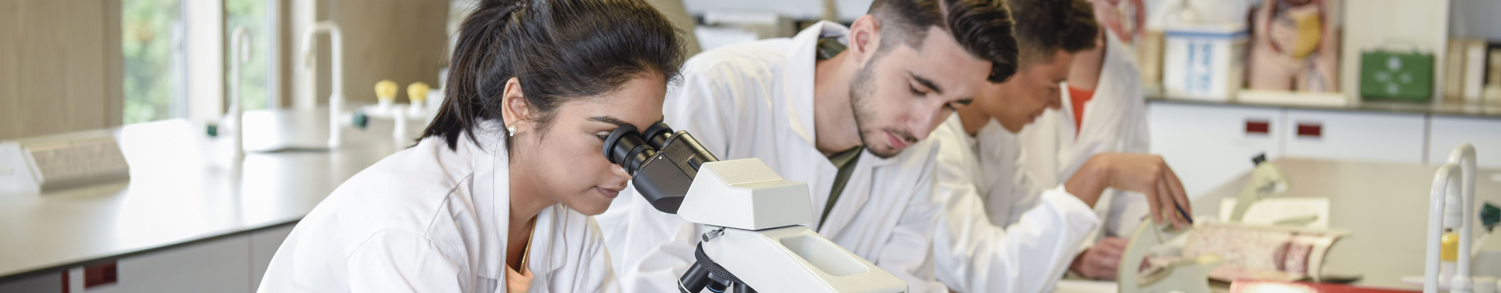 People in lab coats at a lab bench