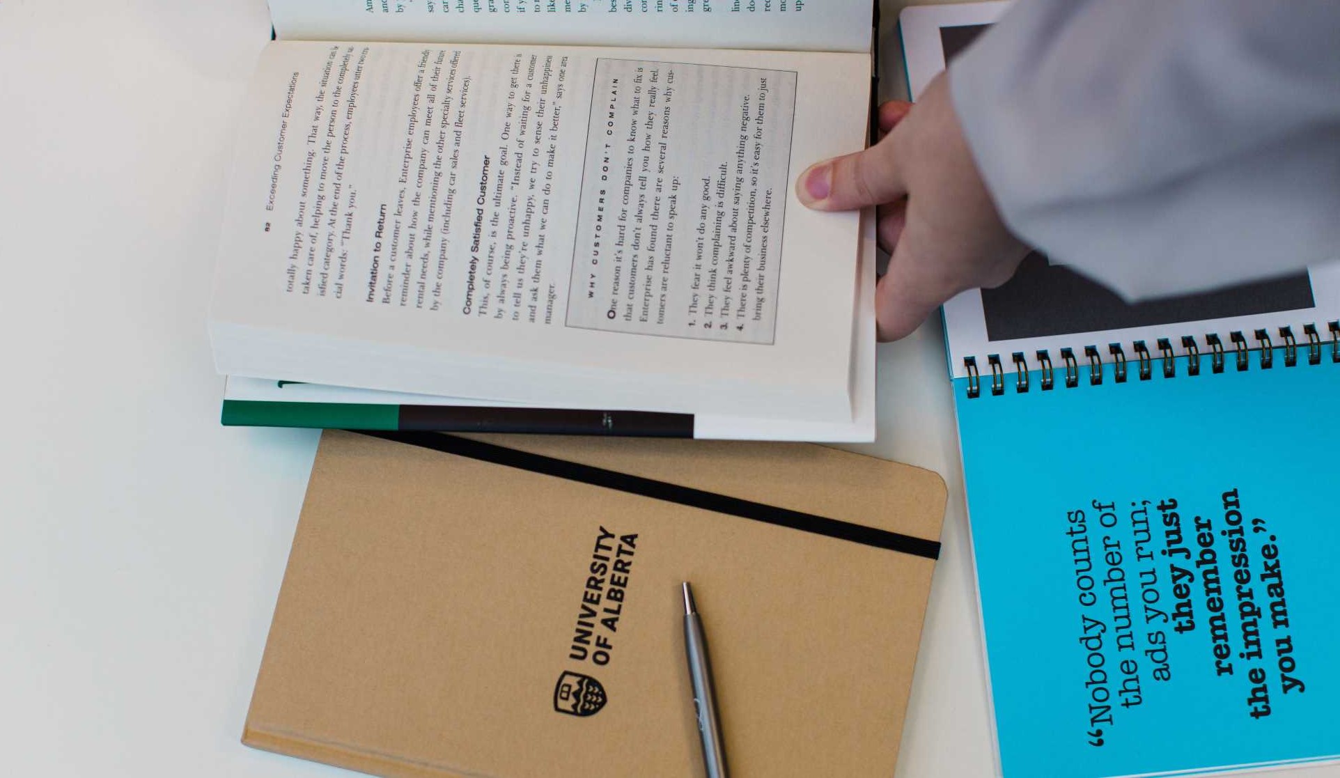 A hand over some notebooks lying on a table