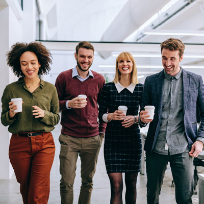 Colleagues walking together in an office setting.