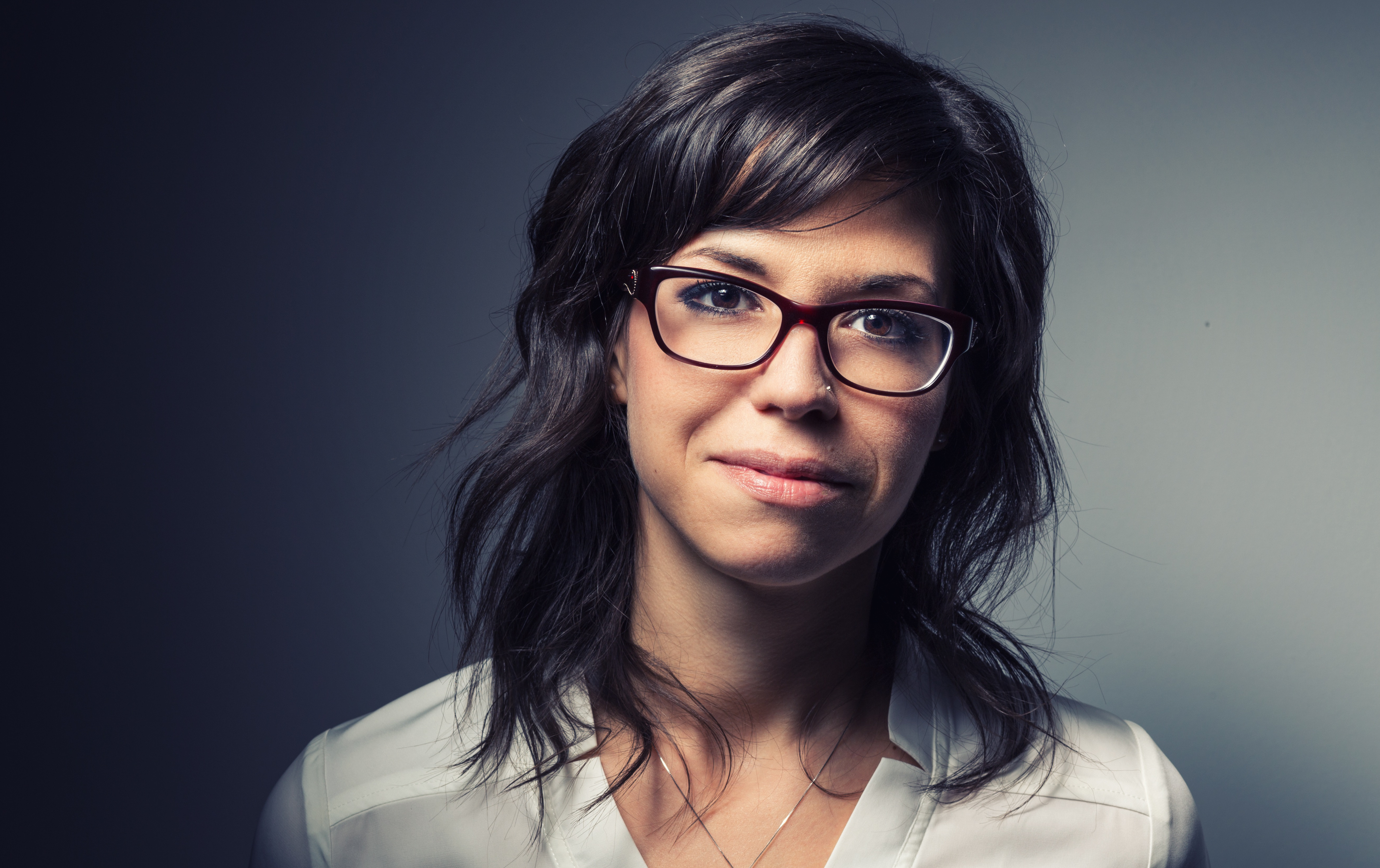 headshot of woman with dark hair and glasses