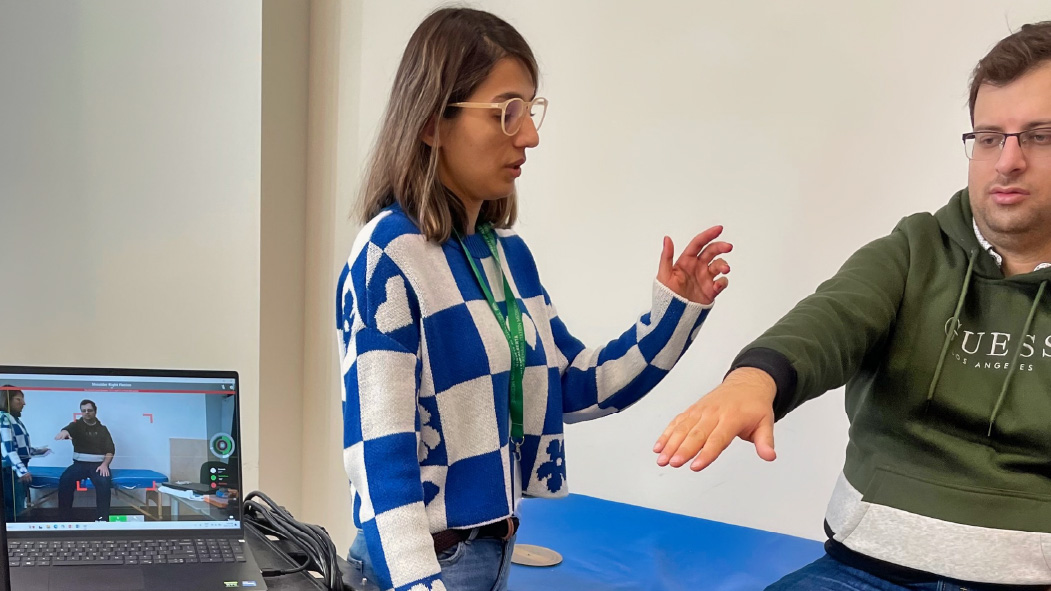 Students Mahtab (standing) and Javad (seated) practise a telerehabilitation procedure using markerless motion capture to measure a patient’s shoulder range of motion.