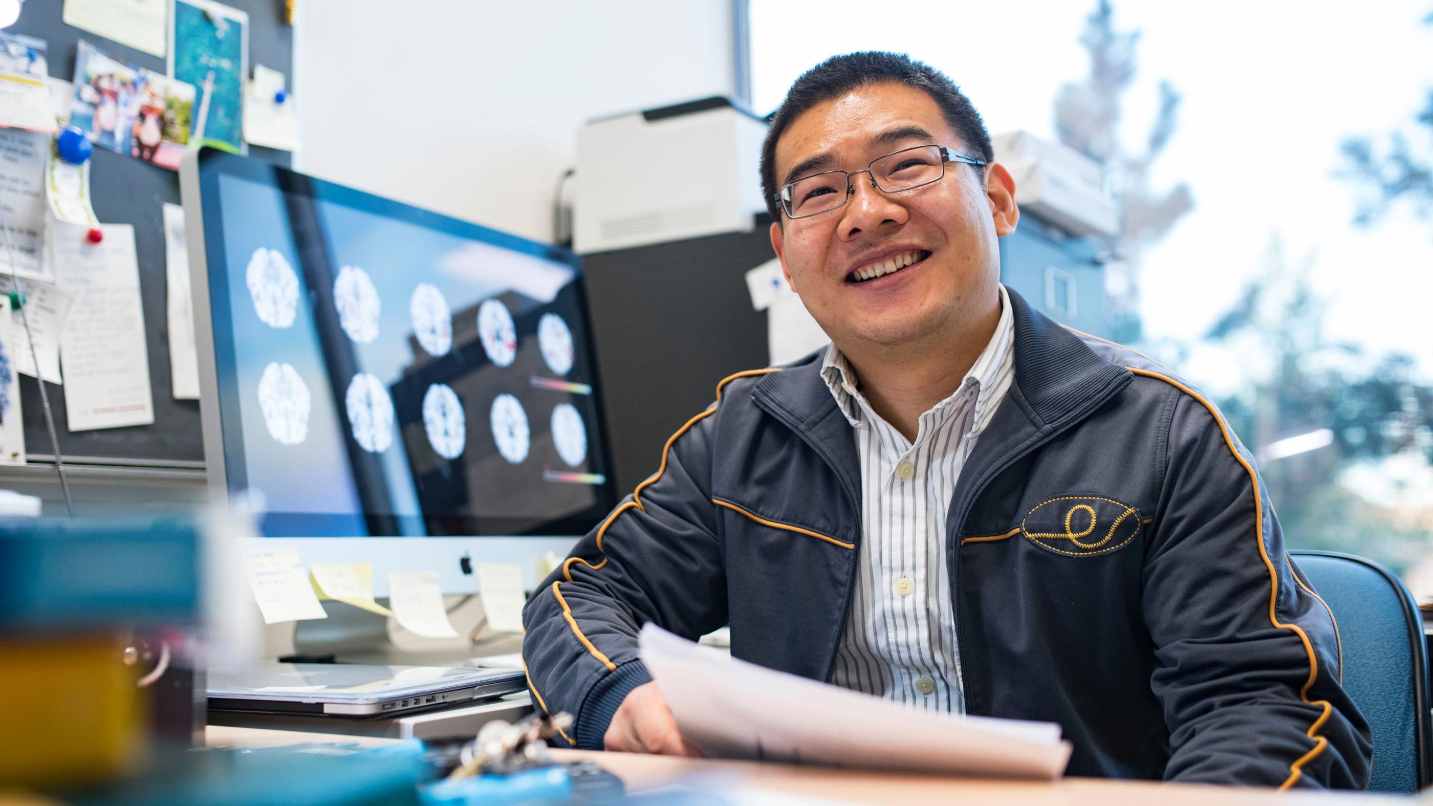 Linglong Kong, newly appointed Canada CIFAR Chair in AI, sitting at his desk