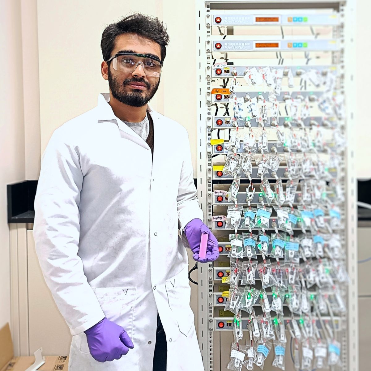 Anil Kumar Vinayak in front of a bank of batteries