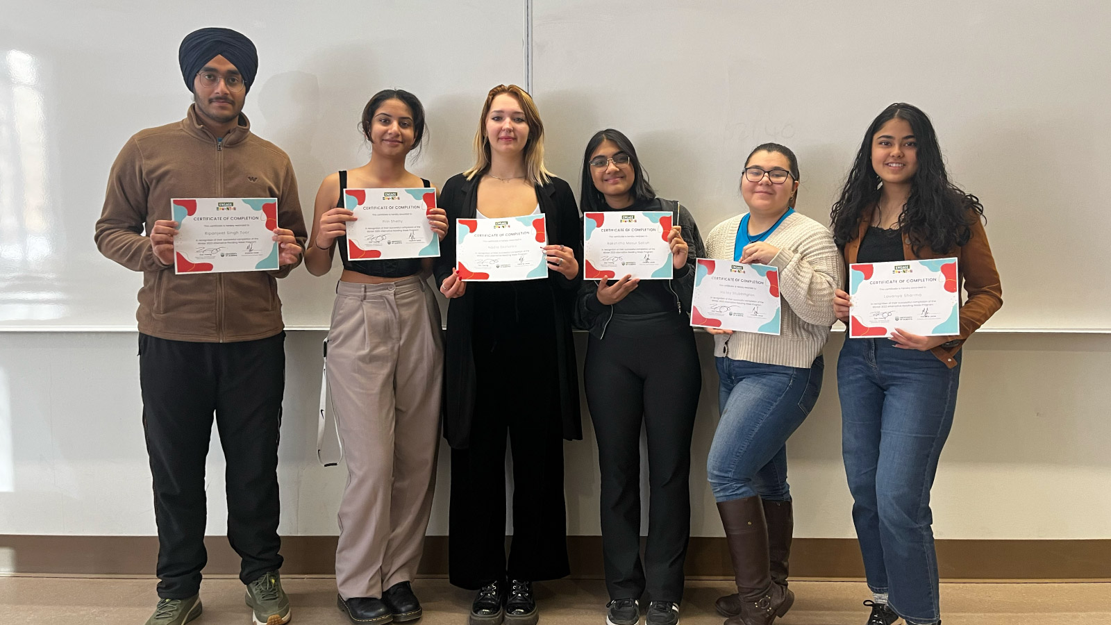 Six students standing holding certificates in hands.