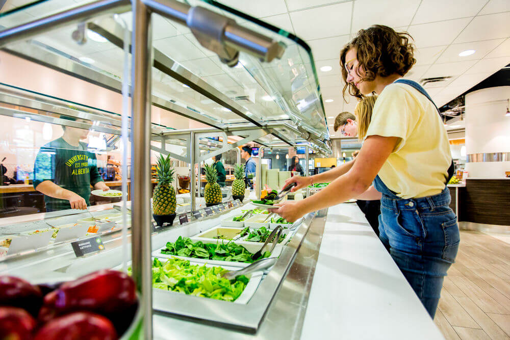 UAlberta student grabbing salad in dining hall