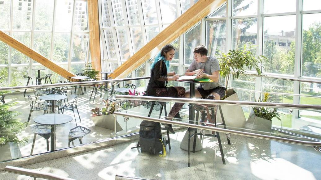 two students sit in the atrium of the agriculture forestry building