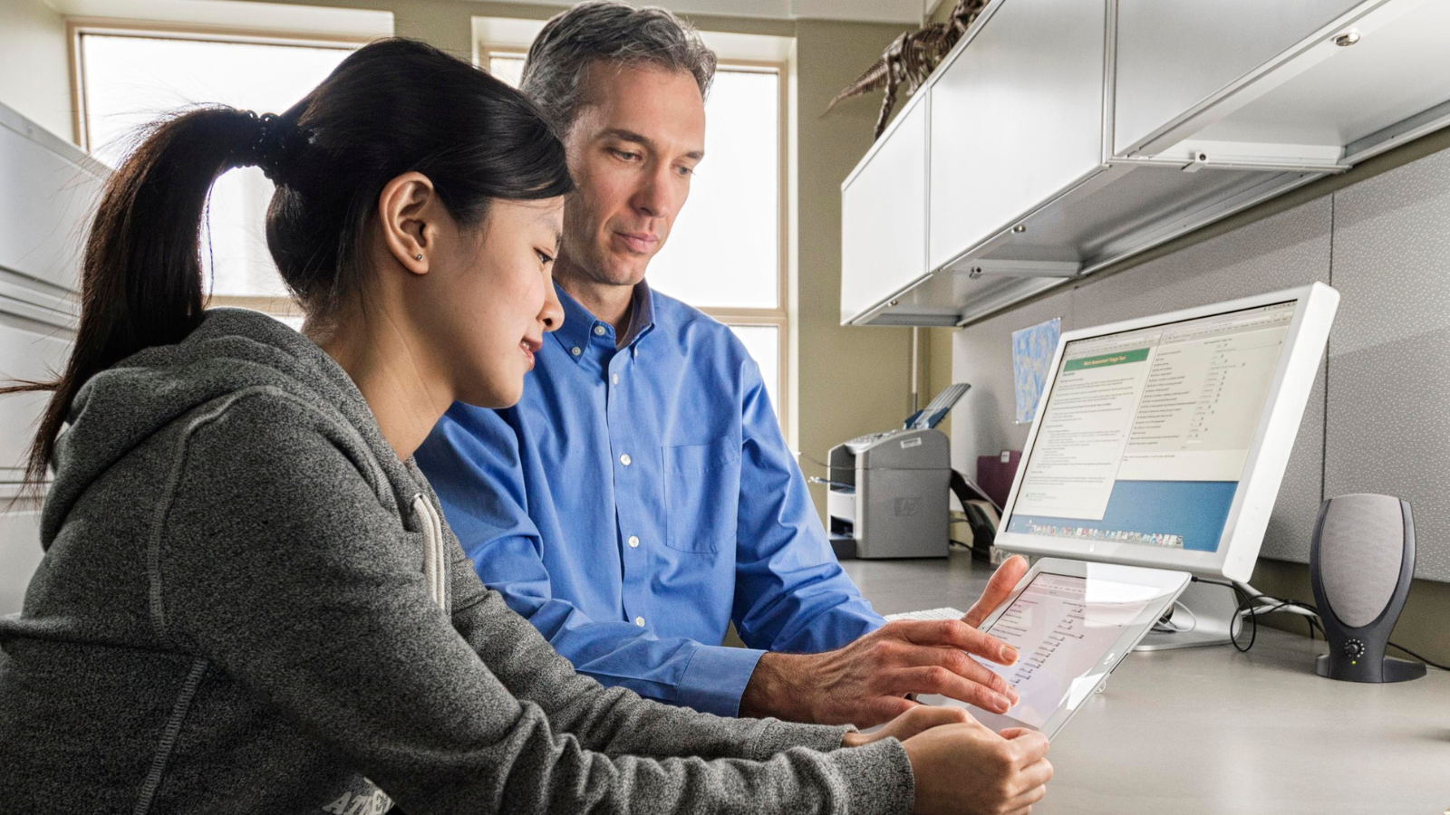 Researchers looking at a computer screen and a tablet.