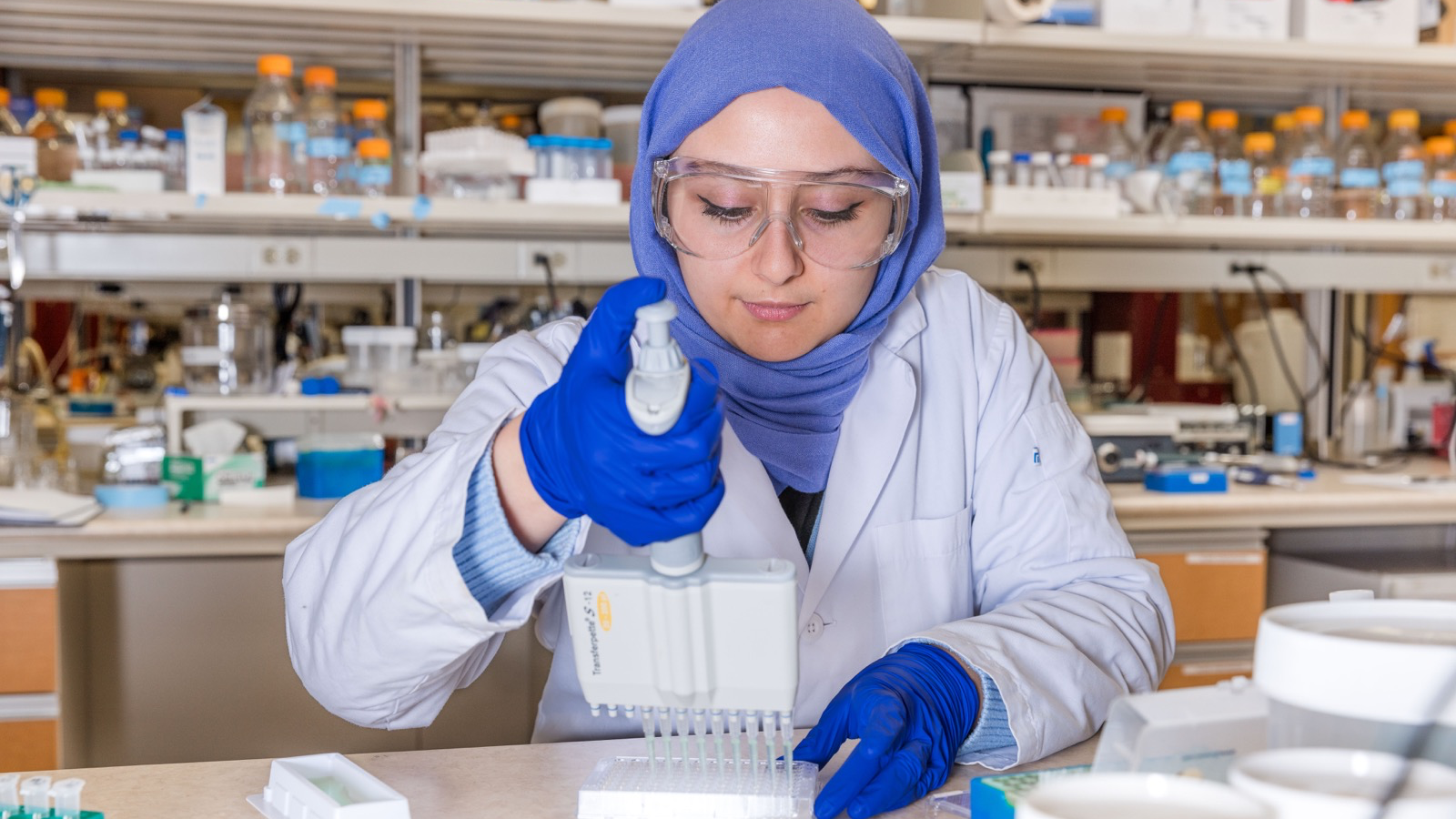 Researcher working at a lab bench with containers and instruments