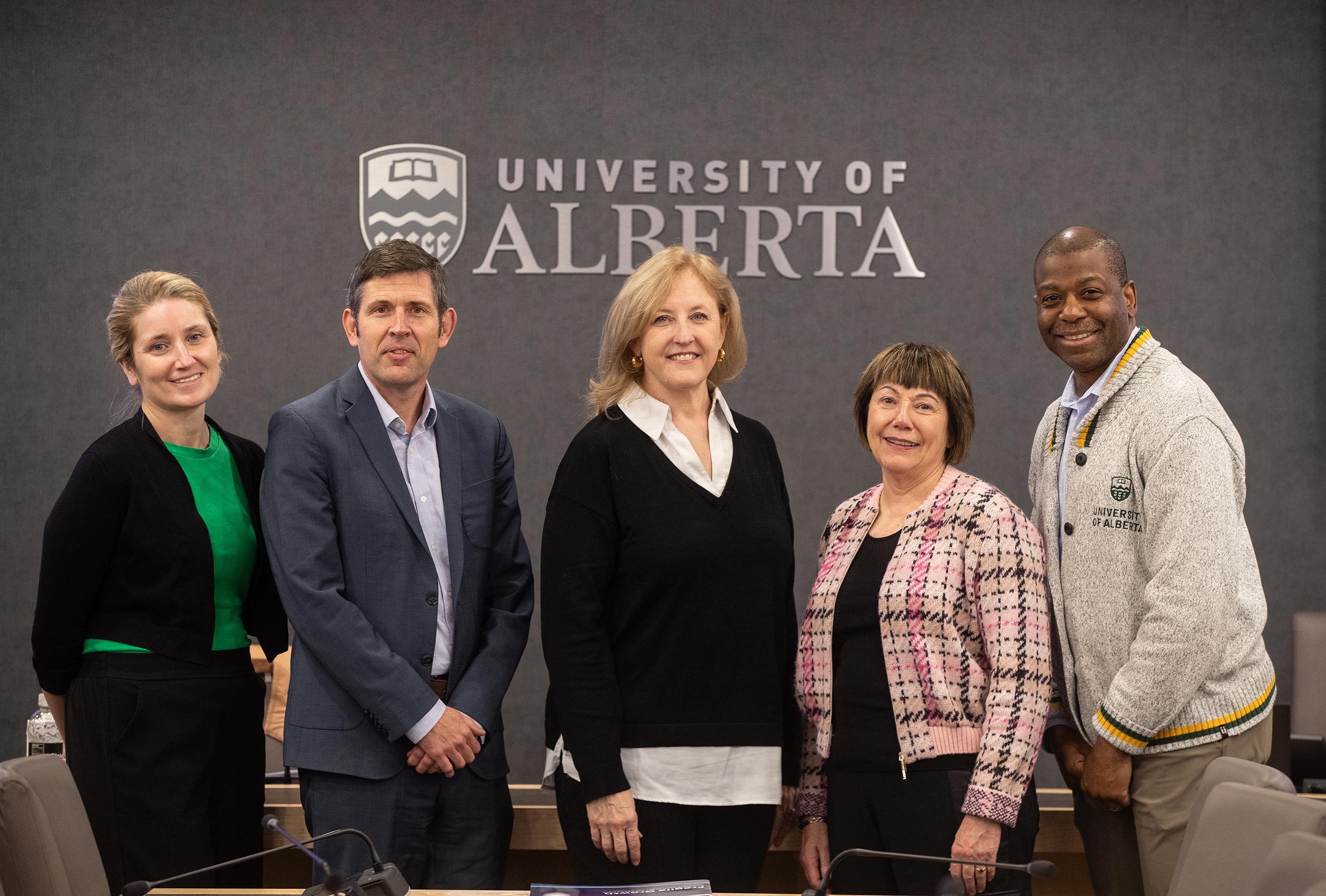 Andrea Hepp, Simon Dyer, Hon. Lisa Raitt, Hon. Anne McLellan, and Marvin Washington standing by a University of Alberta logo