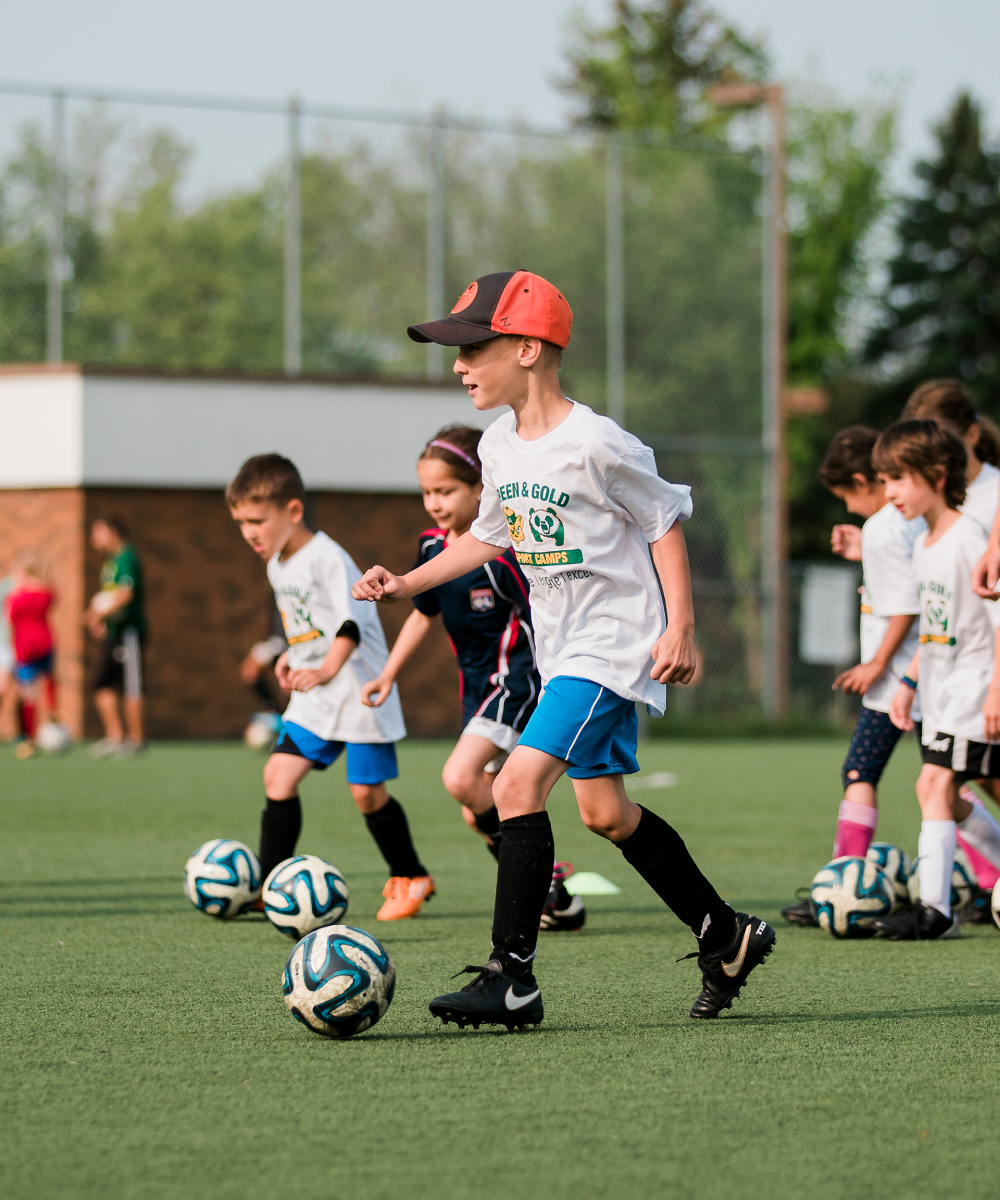 Kids playing soccer at Green + Gold summer camp