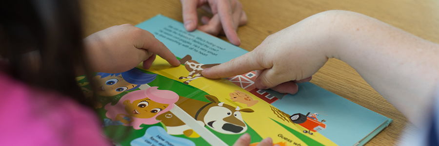 People pointing to a picture in a book