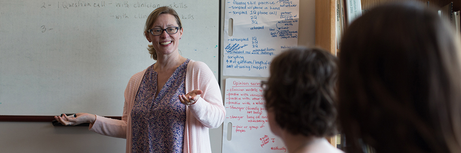 Woman at whiteboard in front of a class