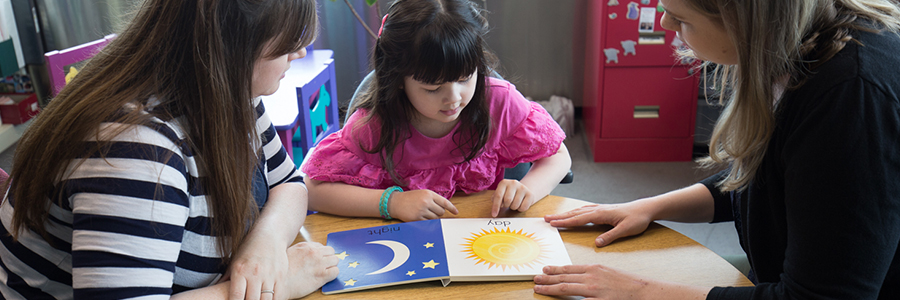 Women at table reading to child