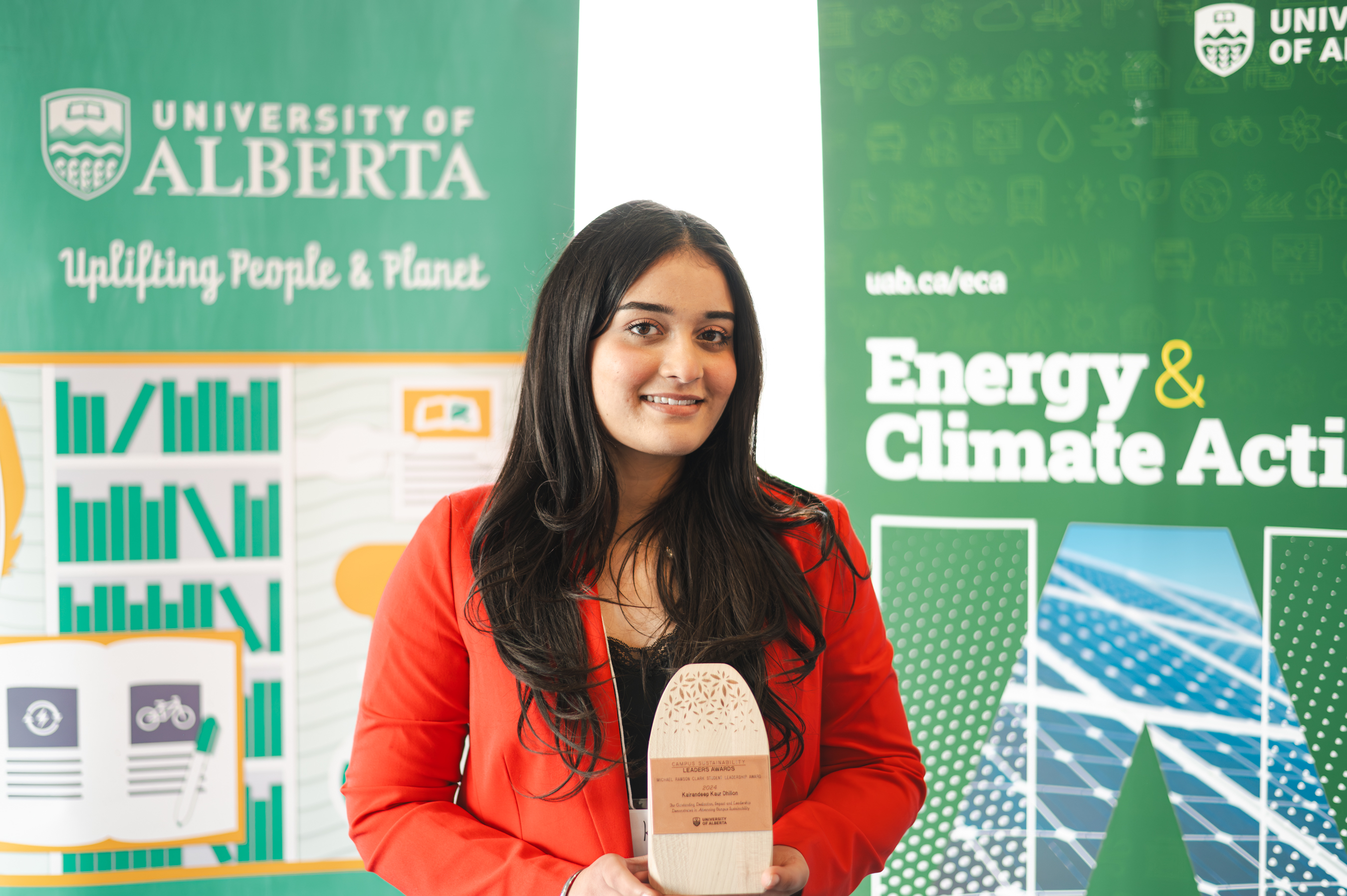 Kairandeep Kaur Dhillon smiling and holding her trophy