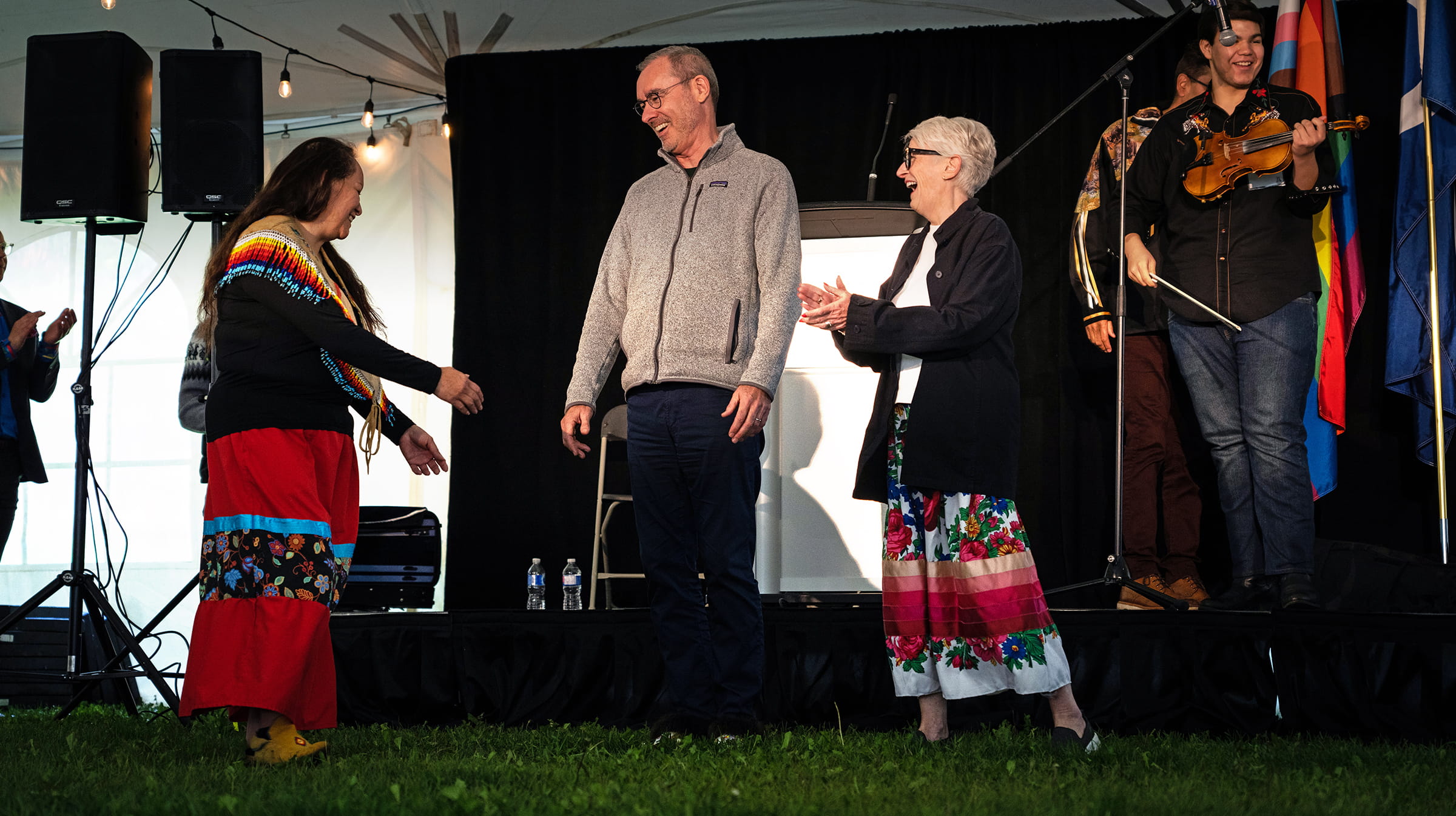 Elder Heather tries to convince Bill and Peggy to jig to Zach Willier’s fiddling.