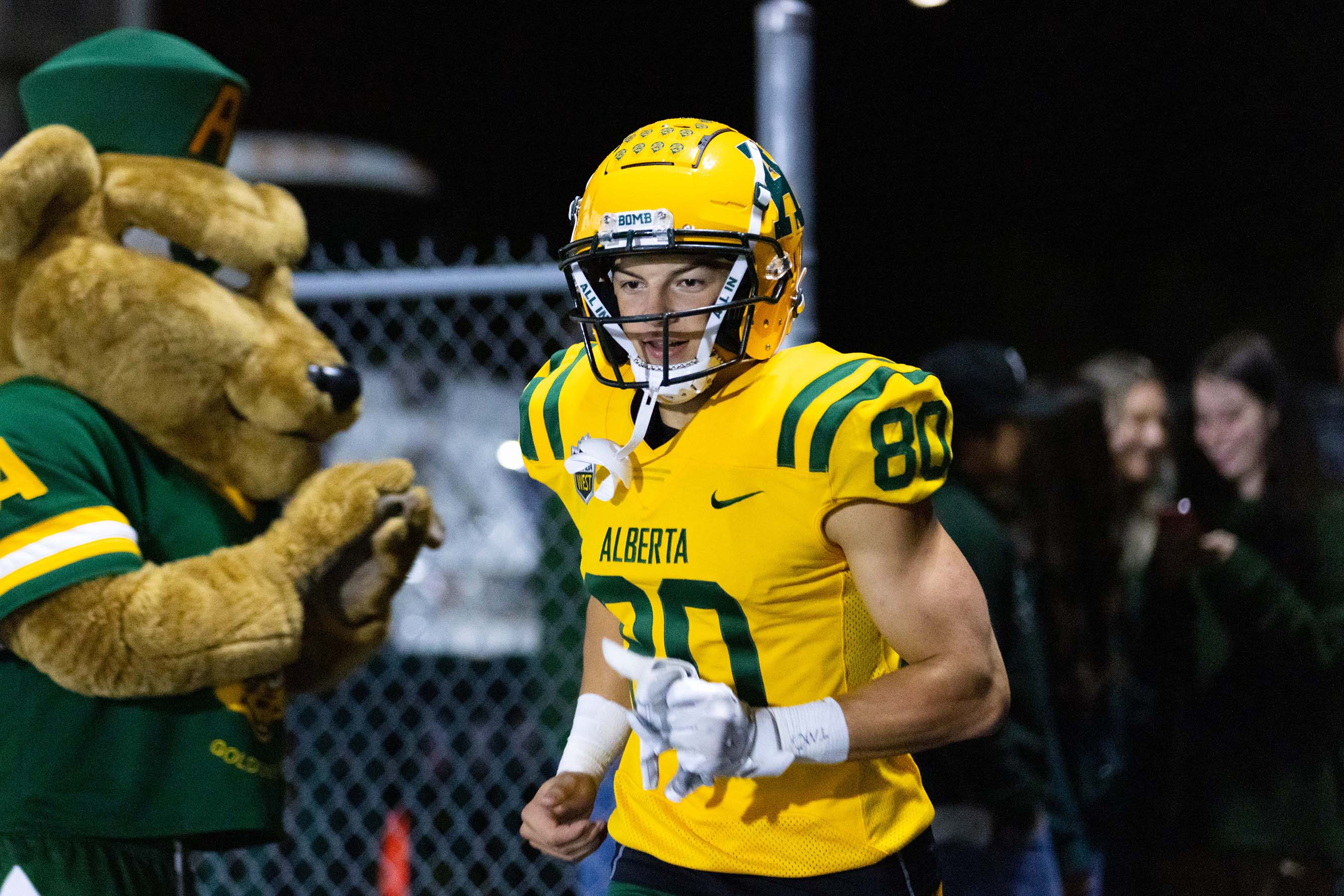 Guba, the Golden Bears mascot, cheers as Golder Bears players take to the field 