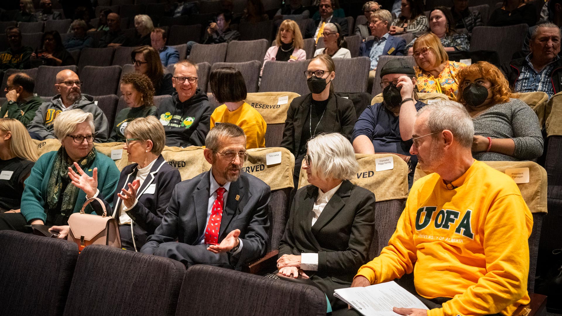 President Bill Flanagan and other guests talk in their seats before the event starts