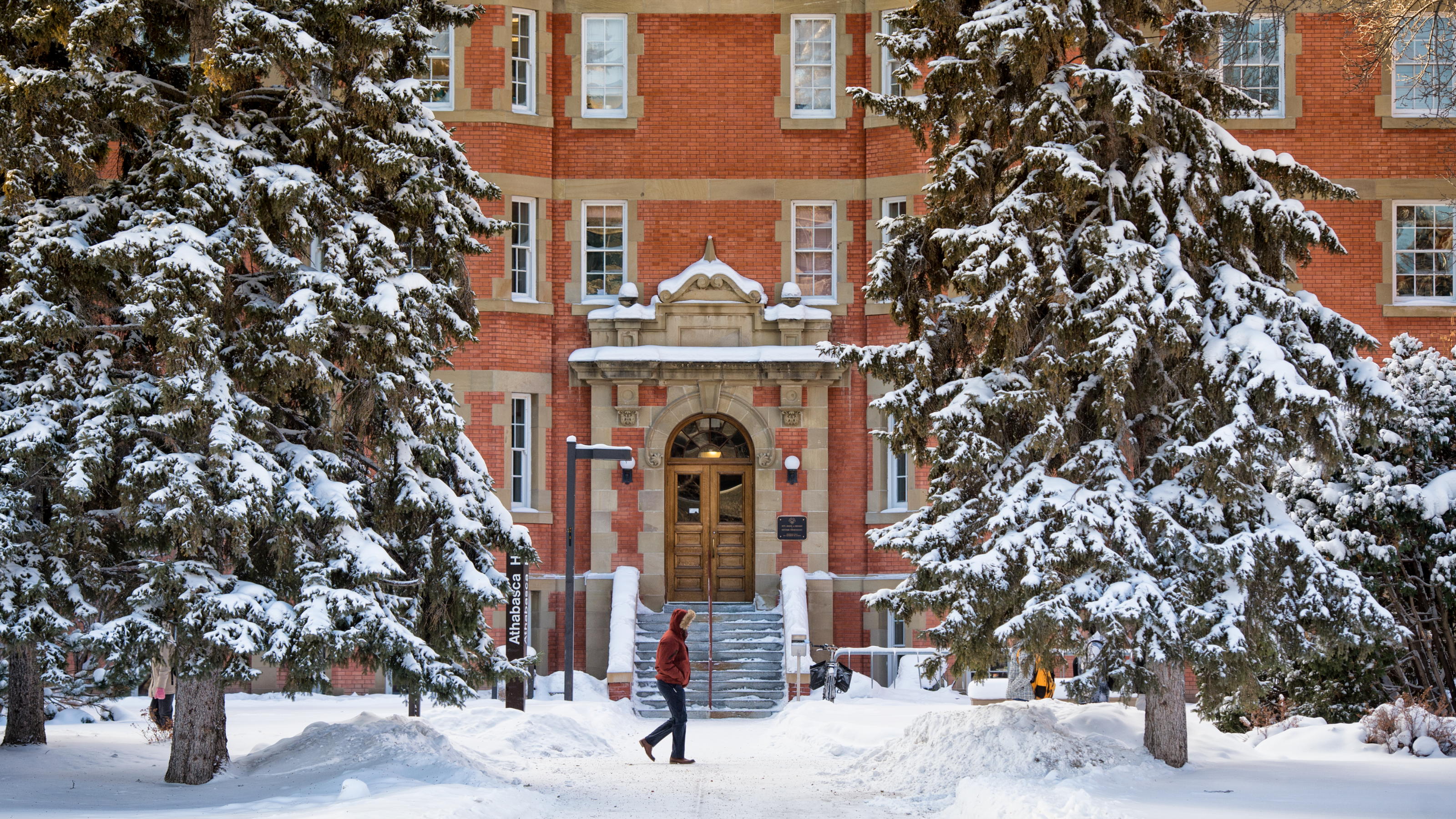 Person walking through the snow on main campus.