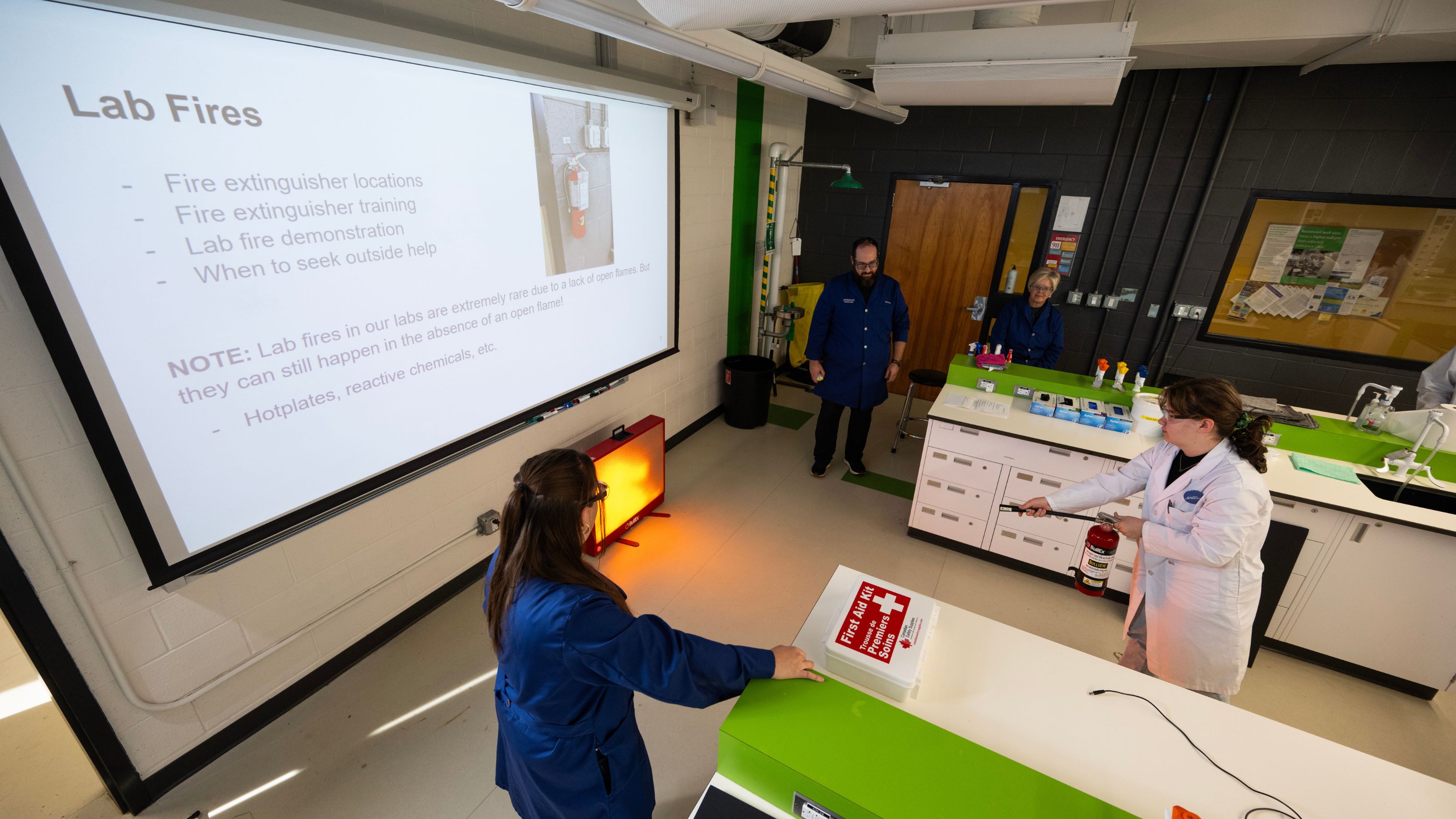 Student Amber Hutton practicing the proper method of putting out a lab fire with a fire extinguisher.