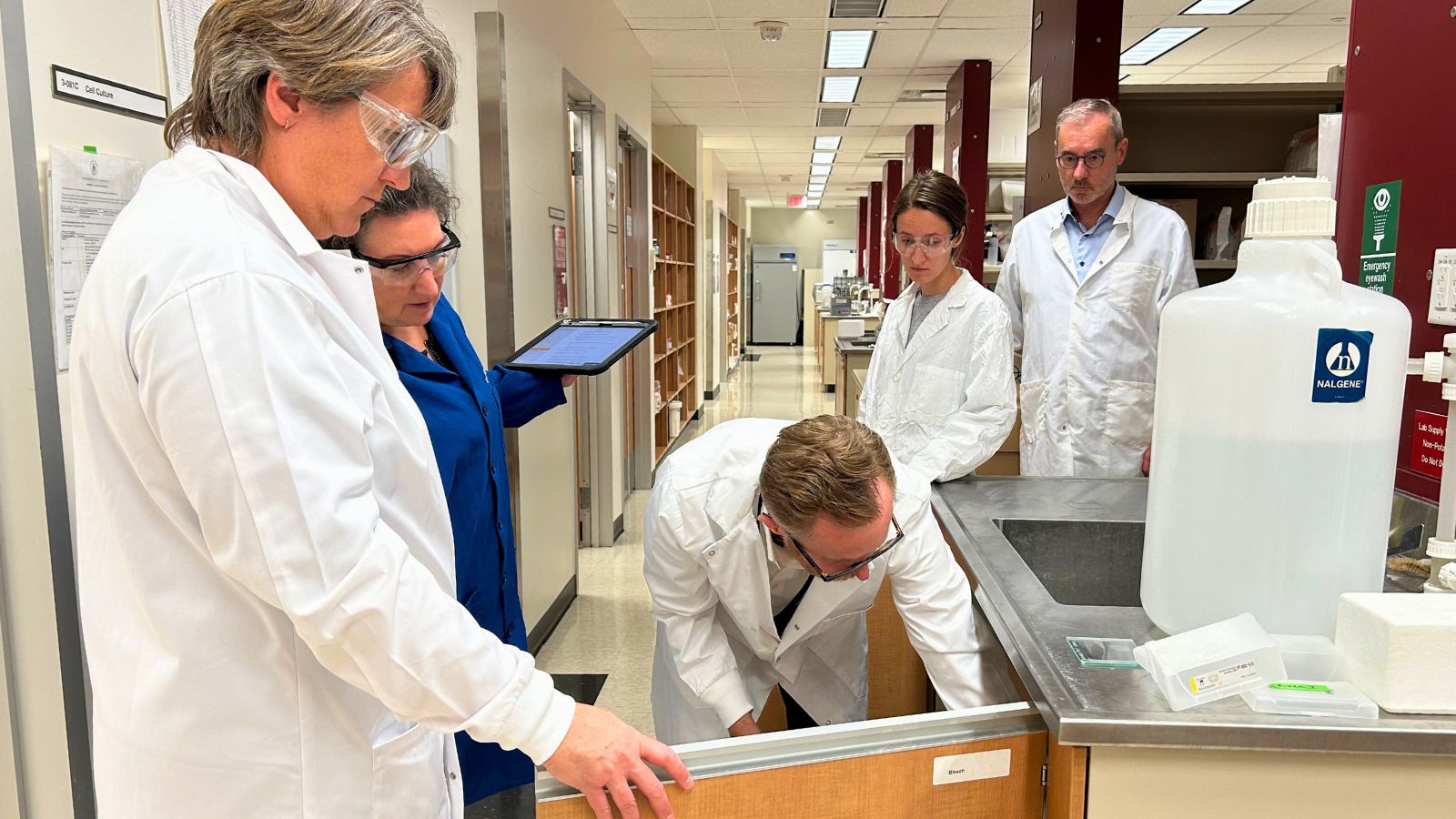 President Flanagan joins Paul Jurasz’s pharmacy team during a lab inspection.