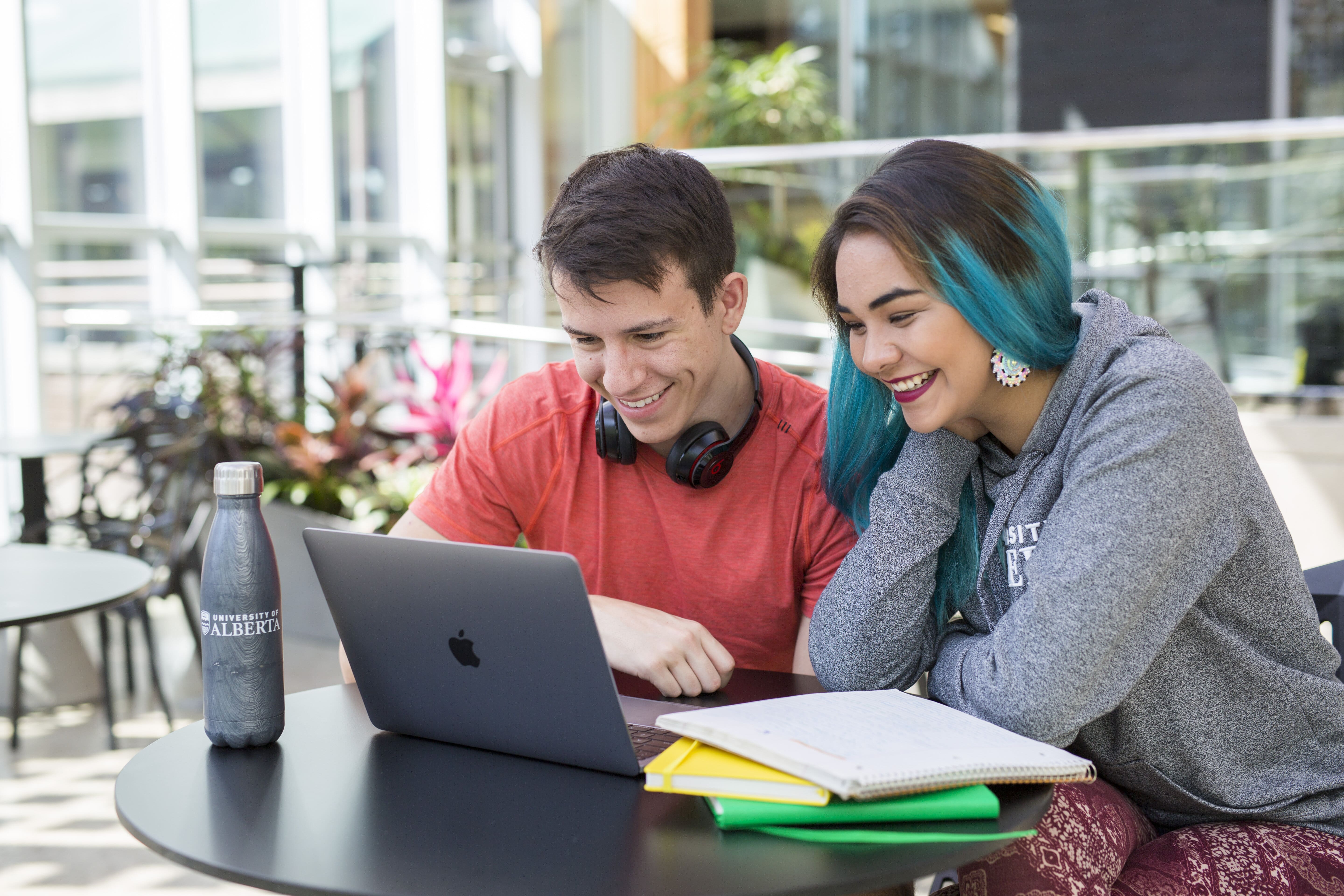 Two students looking at a laptop together.