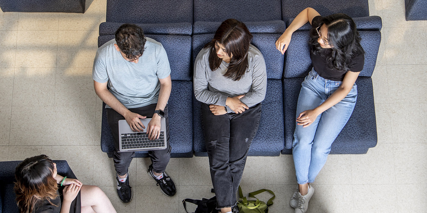 Students sitting on couches in SUB and working on a laptop