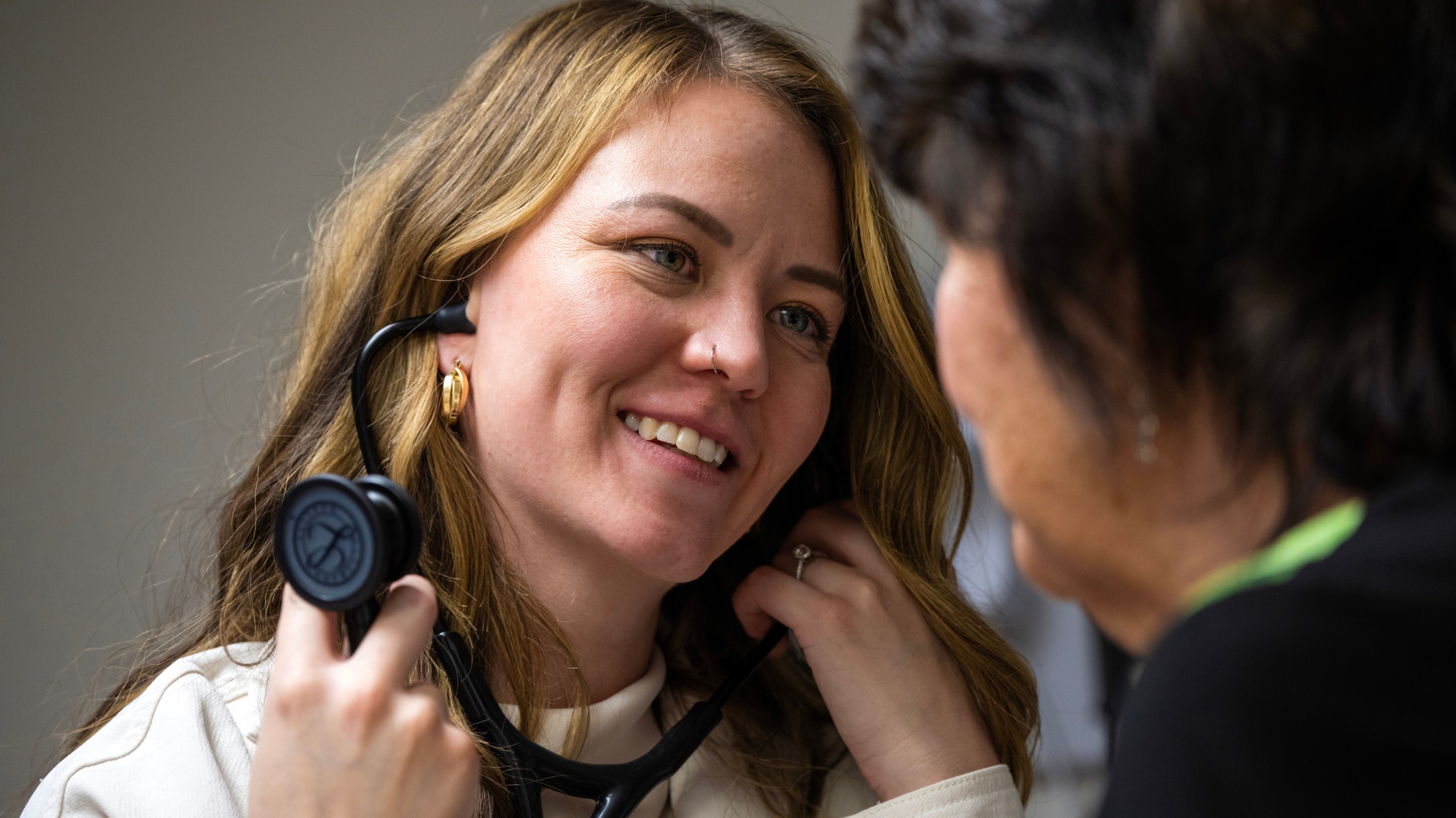 Nurse practitioner MA grad Christie Brulhart works with a patient in the medical clinic where she is taking up practice in Consort, Alta. (Photo: John Ulan)