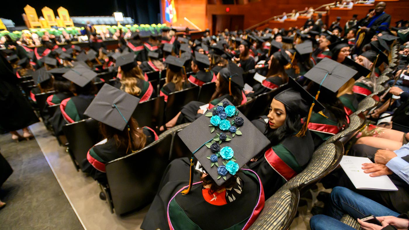 Students sitting in Convocation Hall wearing their mortarboards