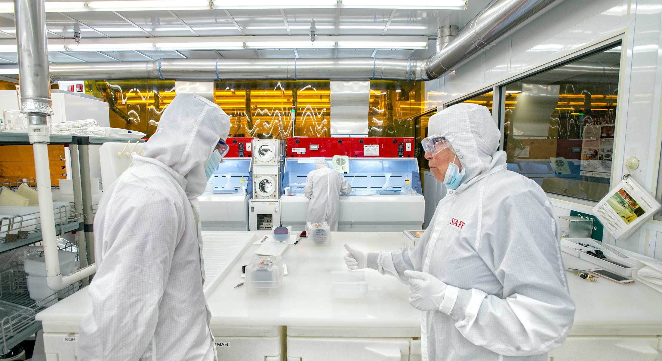 Two researchers wearing protective suits in a laboratory