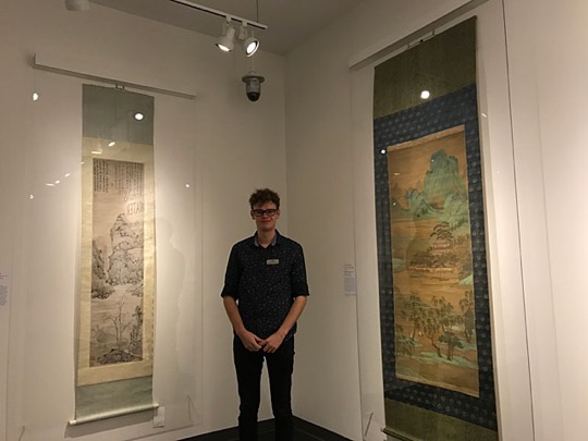 Martin standing between two hanging scrolls