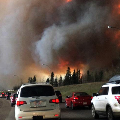 Fires burning in Fort McMurray while cars try to evacuate.